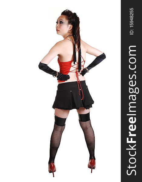 An young pretty Chinese woman in an short black skirt, cloves and black stockings, red heels and top standing in the studio for white background. An young pretty Chinese woman in an short black skirt, cloves and black stockings, red heels and top standing in the studio for white background.