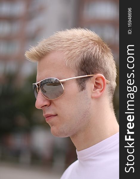 Portrait of the young blonde man in sunglasses