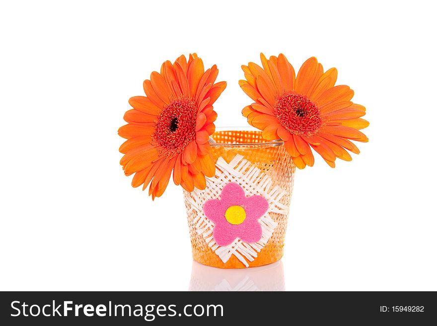 A little vase with colorful gerbera daisies isolated over white. A little vase with colorful gerbera daisies isolated over white