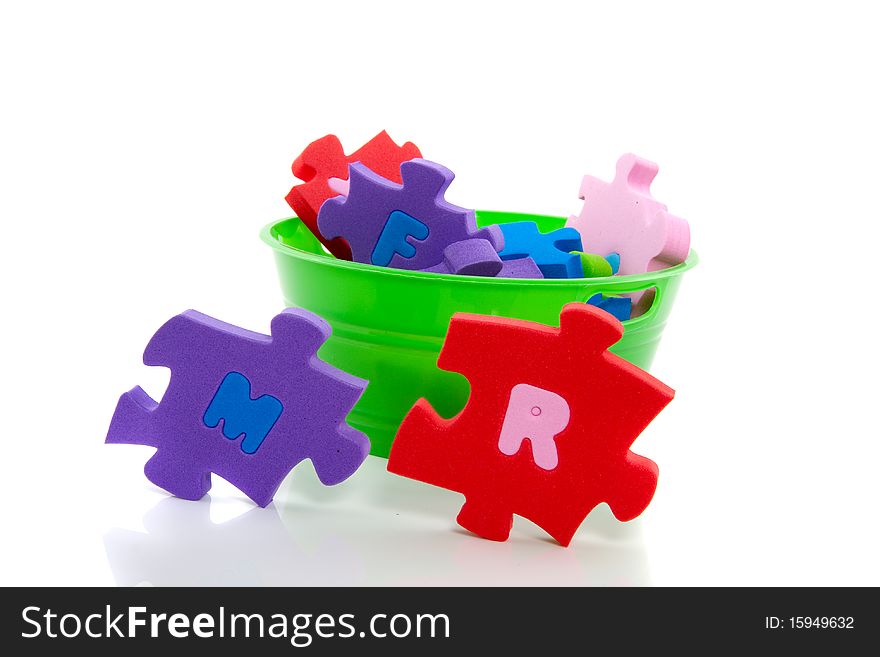 A green plastic tray with an instructive colorful  ABC puzzle isolated over white. A green plastic tray with an instructive colorful  ABC puzzle isolated over white