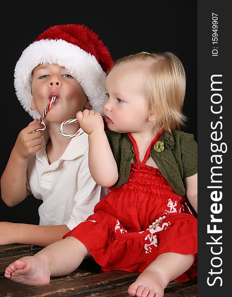 Christmas brother and sister eating Candy Canes. Christmas brother and sister eating Candy Canes