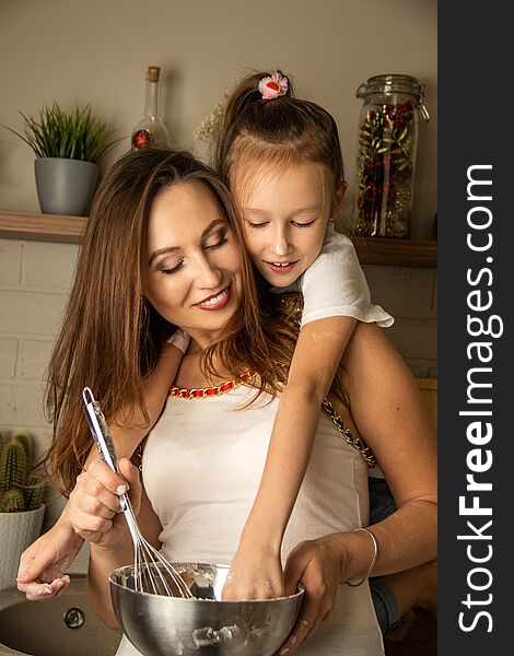 Mom and daughter are playing in the kitchen, messing with flour.