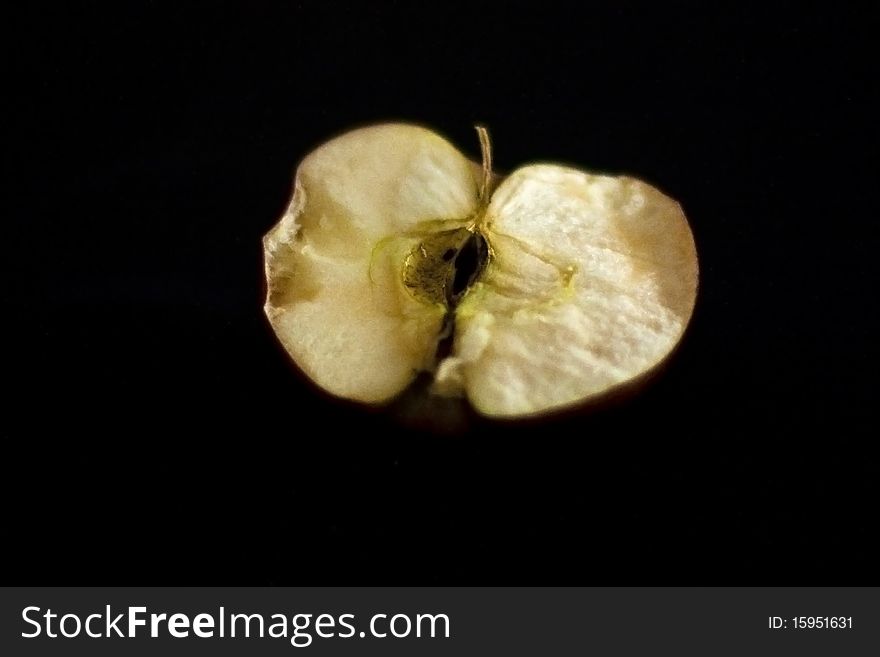 An apple cut in half, rotten on the inside