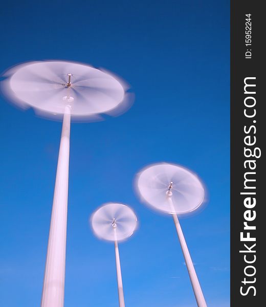 Motion blade of modern win turbine in windy day with blue sky.