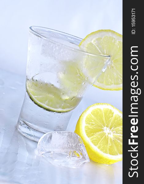 Vodka, lime and lemon in glass with ice. Vodka, lime and lemon in glass with ice