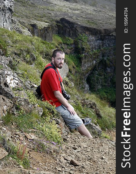 Young male traveller, photographer resting and enjoying the beautiful view of mountains in Iceland