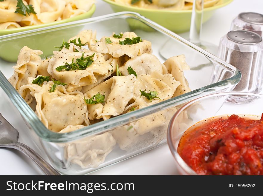 Serving of healthy stuffed tortellini pasta with herbs and tomato sauce