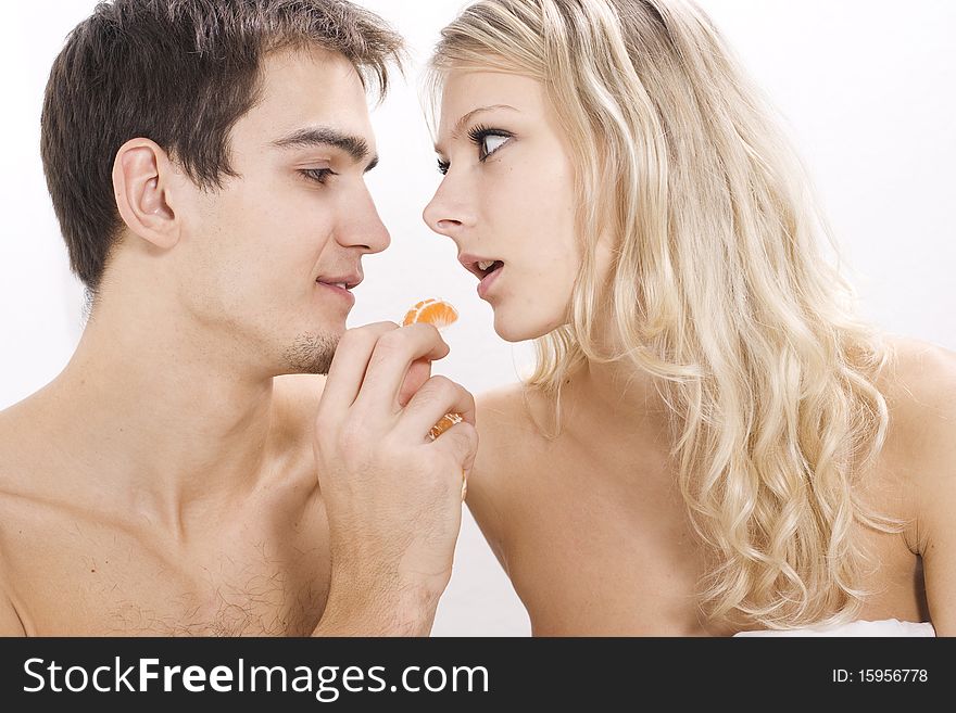 Young couple enjoying fruit breakfast in bed. Young couple enjoying fruit breakfast in bed