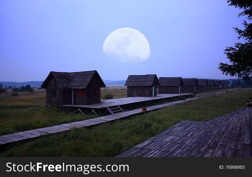 Log cabin with the moon at night.