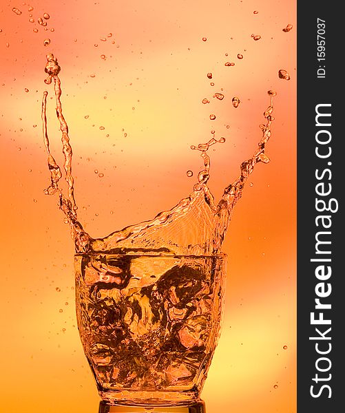 Whisky and ice. Splashing scotch on brown background. Whisky and ice. Splashing scotch on brown background
