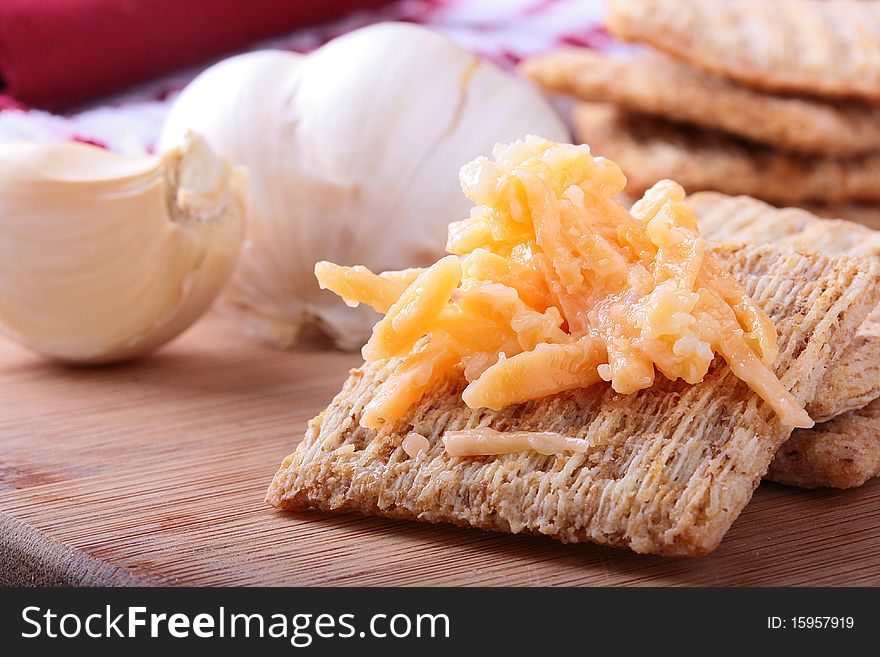 Wheat crackers on a kitchen board with grated cheese. Wheat crackers on a kitchen board with grated cheese.