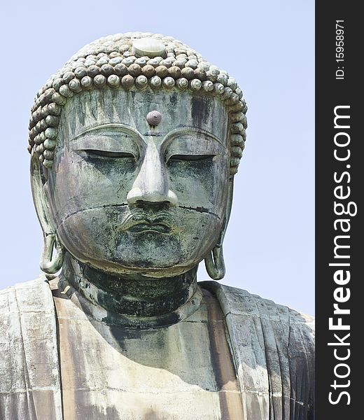 A close-up view of a very big statue of Amida Buddha in Kamakura, Japan, with afternoon light. A close-up view of a very big statue of Amida Buddha in Kamakura, Japan, with afternoon light.