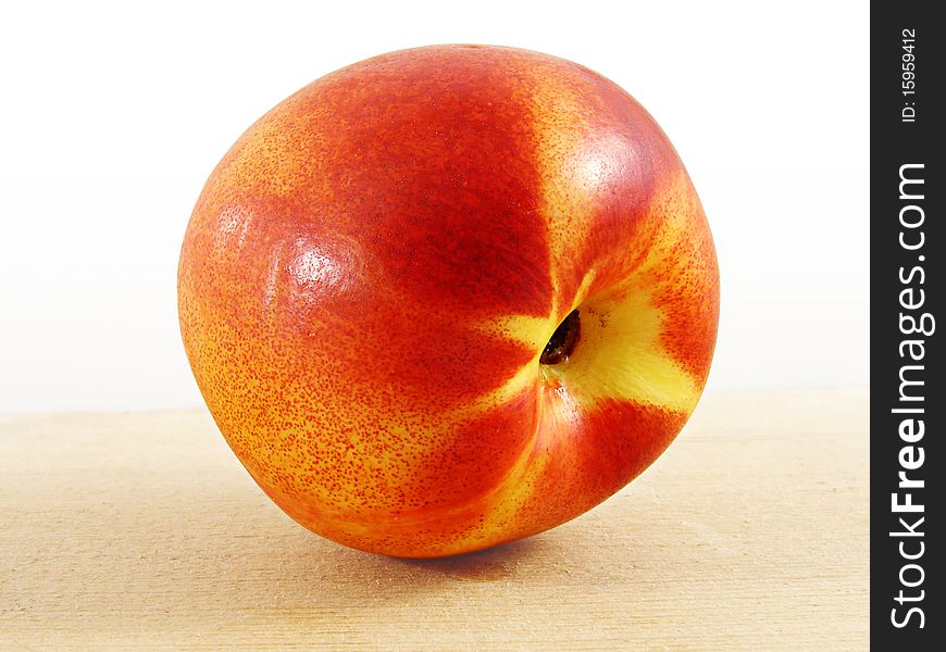 Sweet juicy nectarine, on a wooden surface, in the studio