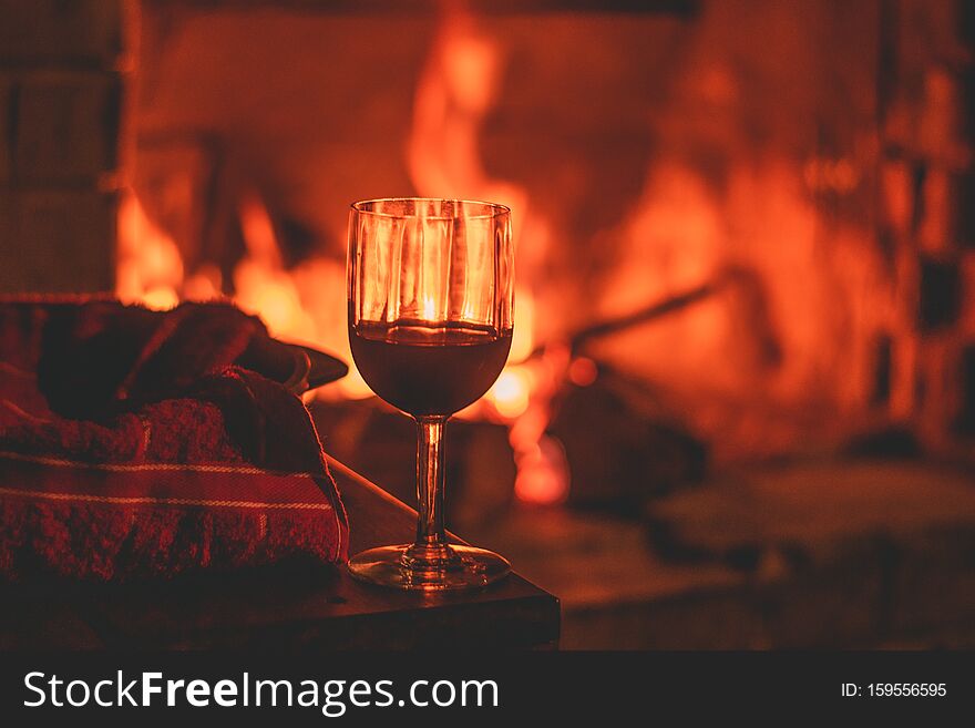 Cup of wine next to a fireplace. Warm enviroment