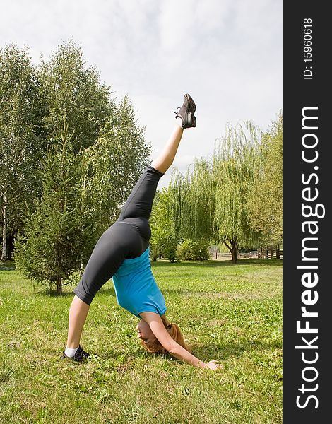 Woman engages in yoga, stands in inclination, heaving up one leg upwards. Woman engages in yoga, stands in inclination, heaving up one leg upwards
