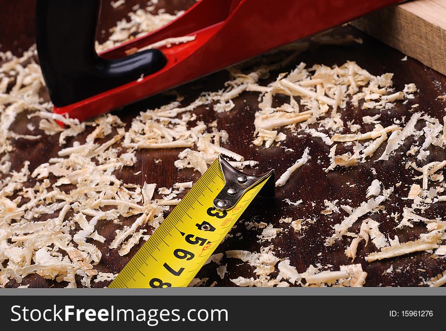 Wood shavings and various construction tools on dark background