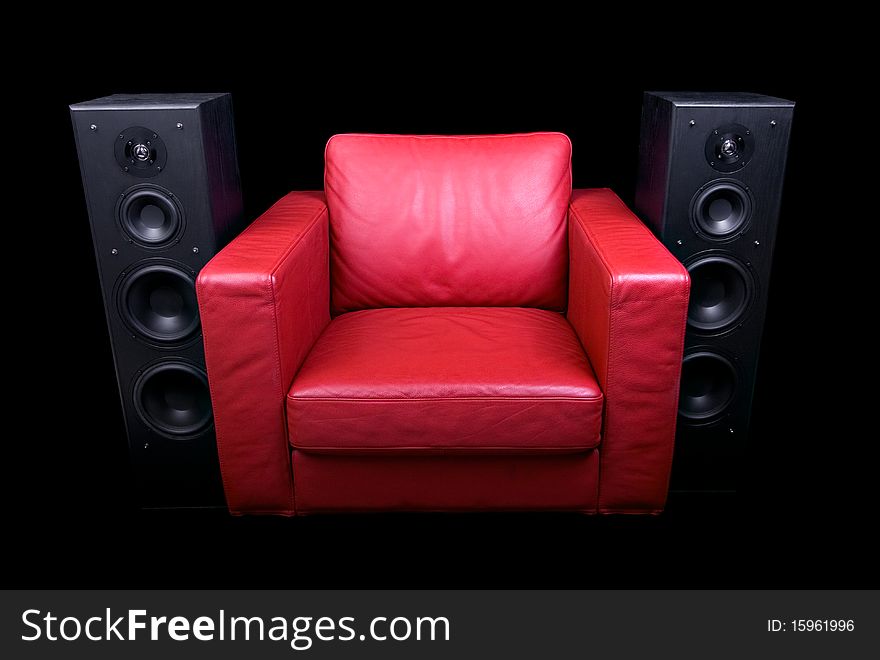 Red leather chair, flanked by speakers and isolated on black. Red leather chair, flanked by speakers and isolated on black.