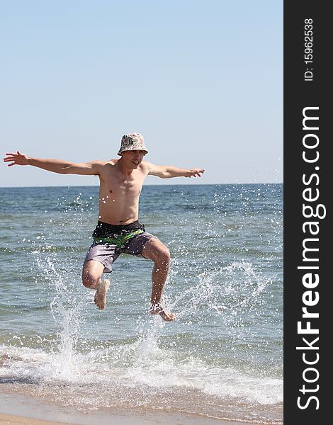 A young man jumping into the sea