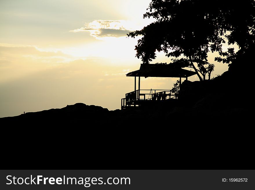 A silhouette image of a hut on a hill by the sea. Location - Perhentian Island, Malaysia. A silhouette image of a hut on a hill by the sea. Location - Perhentian Island, Malaysia.