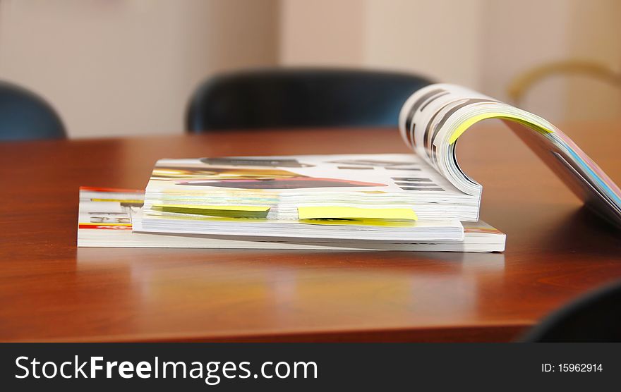 Opened magazines on brown business desk indoor