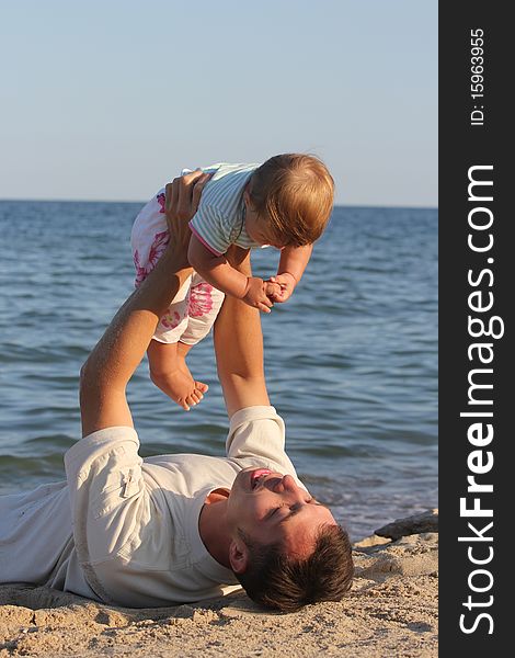 Father and daughter playing near the sea