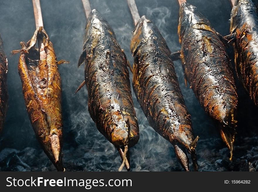 Mackerel with wooden spit on a barbecue