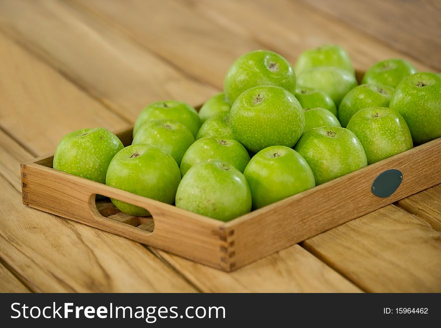 Freshly harvested apples on a wooden tray