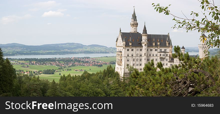 View over the famous Neuschwanstein castle and the lake Forggensee in a misty day. View over the famous Neuschwanstein castle and the lake Forggensee in a misty day.