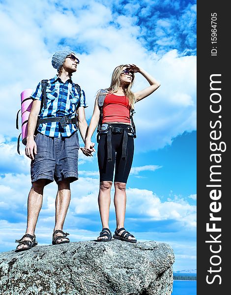 Couple of tourists are standing at the top of a mountain with a feeling of freedom. Couple of tourists are standing at the top of a mountain with a feeling of freedom.