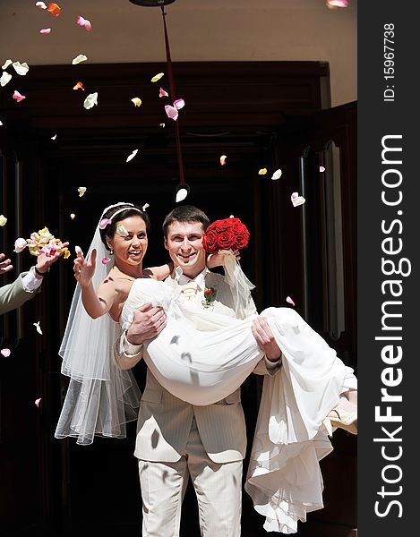 Newly wed couple being showered in rose petals