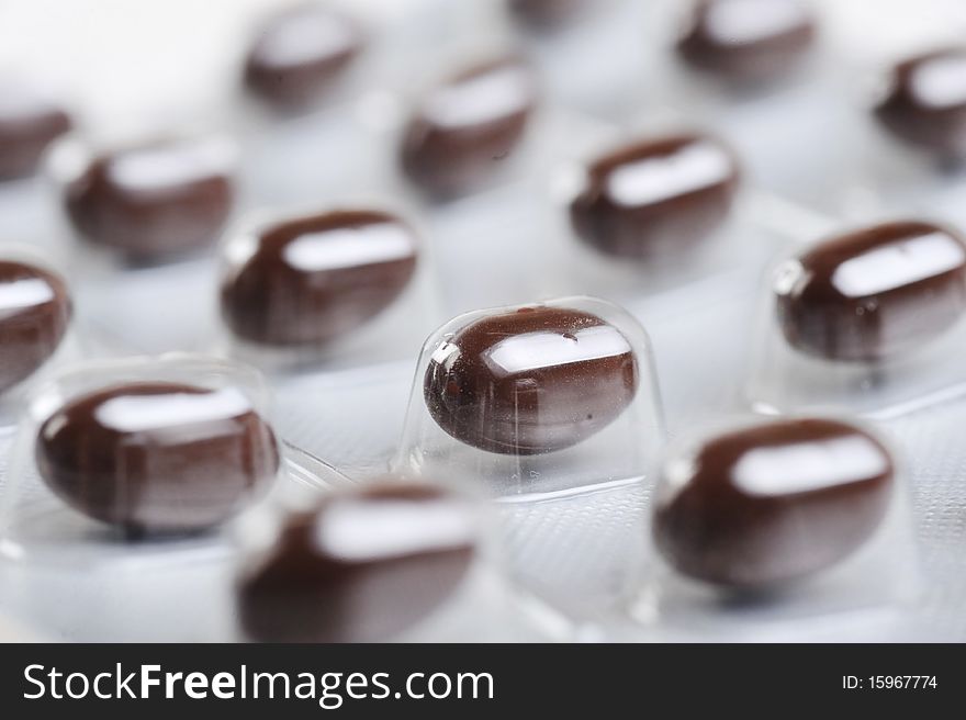 Package of brown pills close up