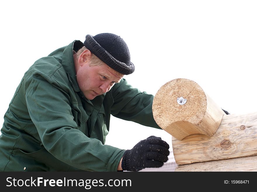 Carpenters works on the wall of log cabin isolated on white. Carpenters works on the wall of log cabin isolated on white