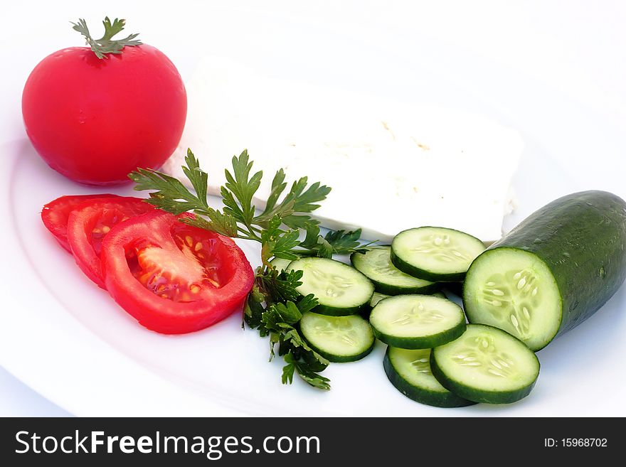 Cheese, tomatoes, and cucumber in a plate on white. Cheese, tomatoes, and cucumber in a plate on white