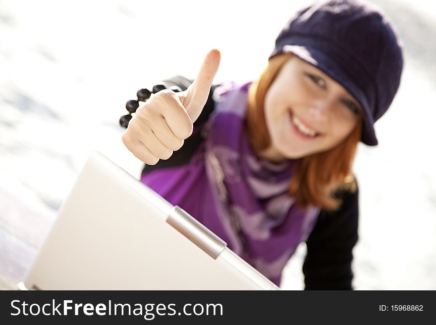 Portrait of red-haired girl with laptop at beach show OK symbol. Portrait of red-haired girl with laptop at beach show OK symbol.