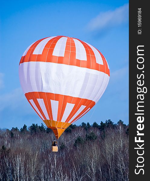 Air ball in flight on background blue sky(heaven) and winter wood. Air ball in flight on background blue sky(heaven) and winter wood