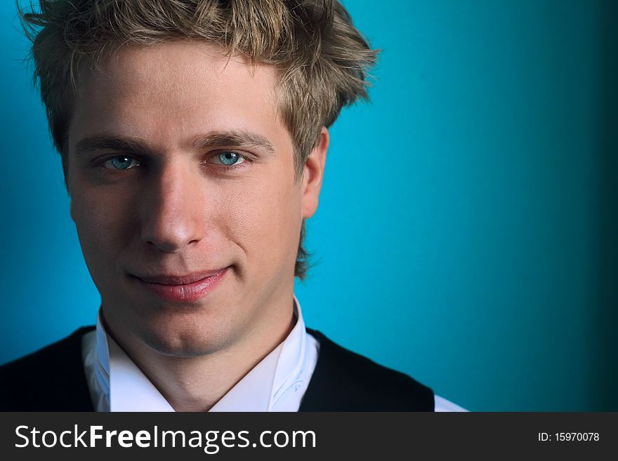 The guy with blue eyes against a turquoise wall