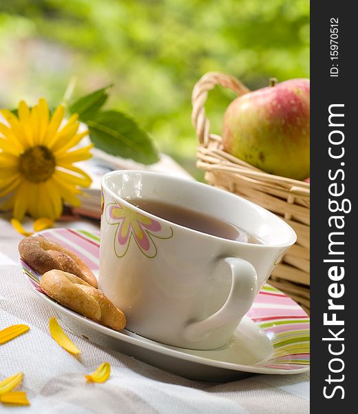 Tea with cookies, the book and flowers on background