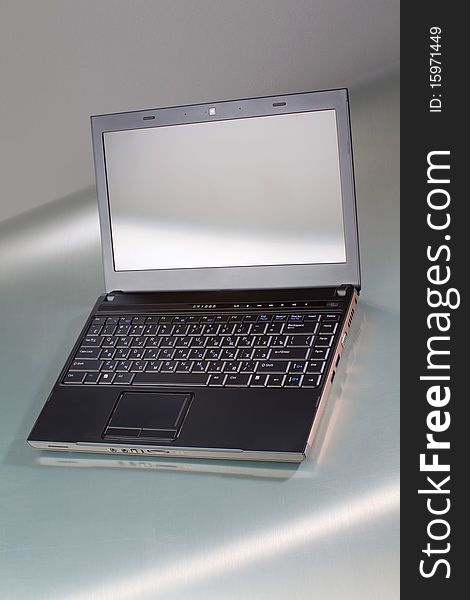 Laptop on a gray table with reflection