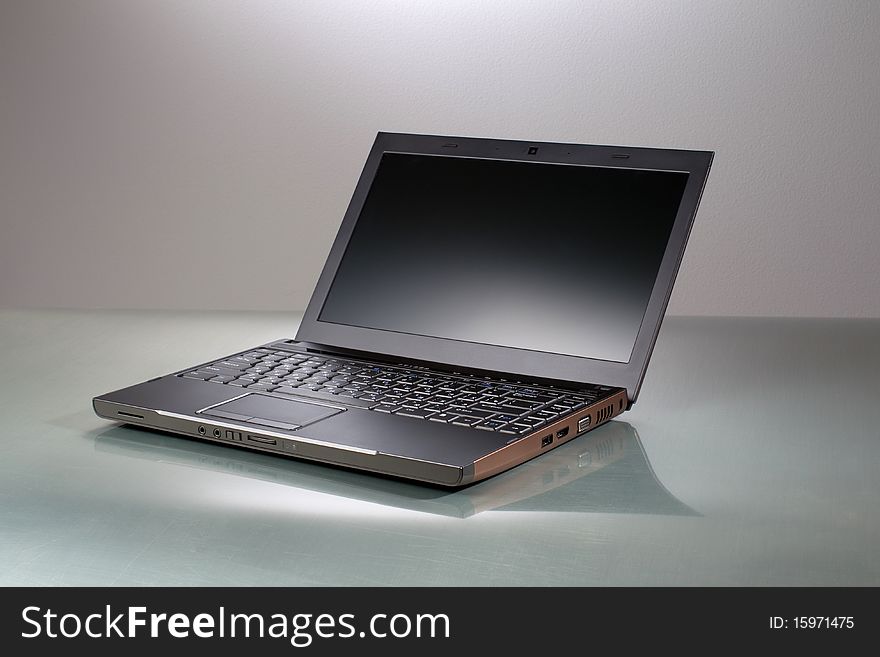 Laptop on a gray table with reflection