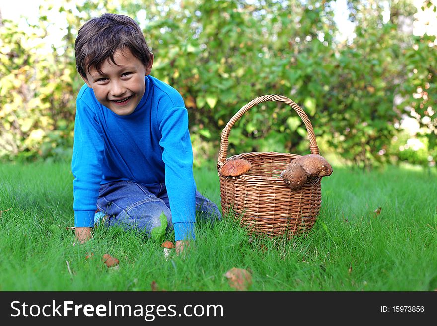 Little boy posing outdoors with mushrooms. Little boy posing outdoors with mushrooms