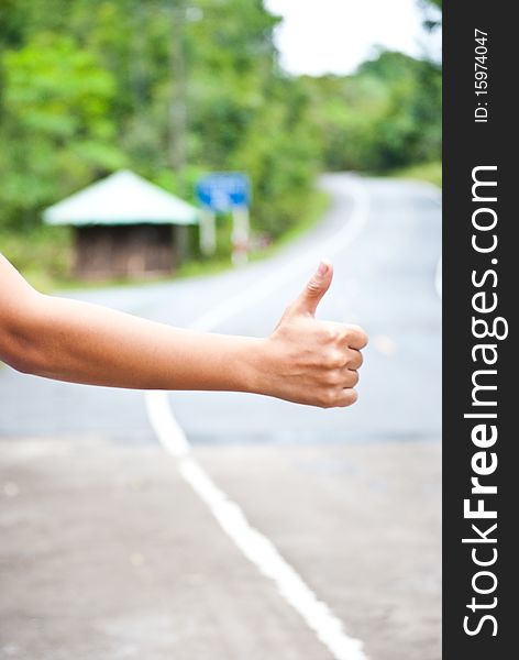 à¹‰Hand thumb outstretched hitchhiking on road. à¹‰Hand thumb outstretched hitchhiking on road