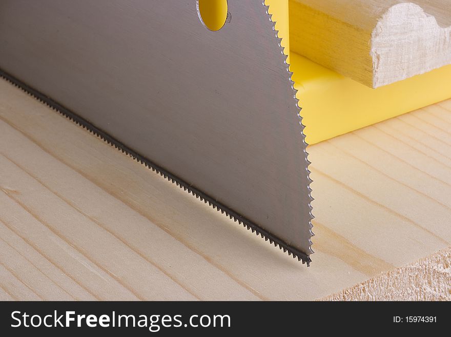 Sharp saw blade on a piece of wood next to a miter box.