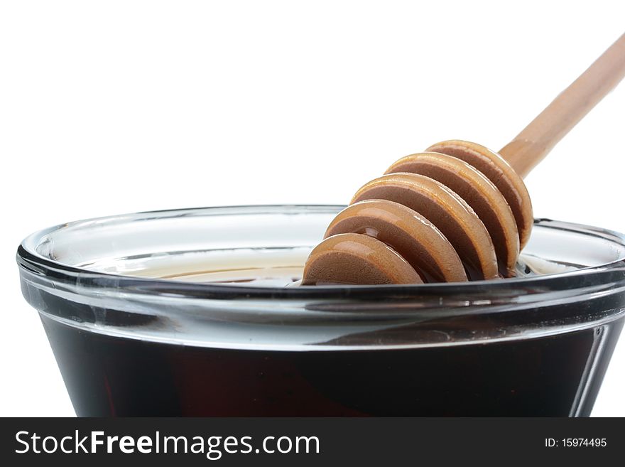 Honey in glasswares with wooden honey dipper.