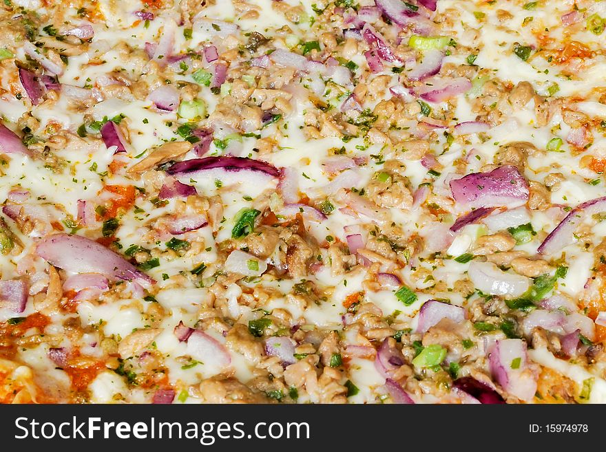 A pizza surfaced with tunny and red onion