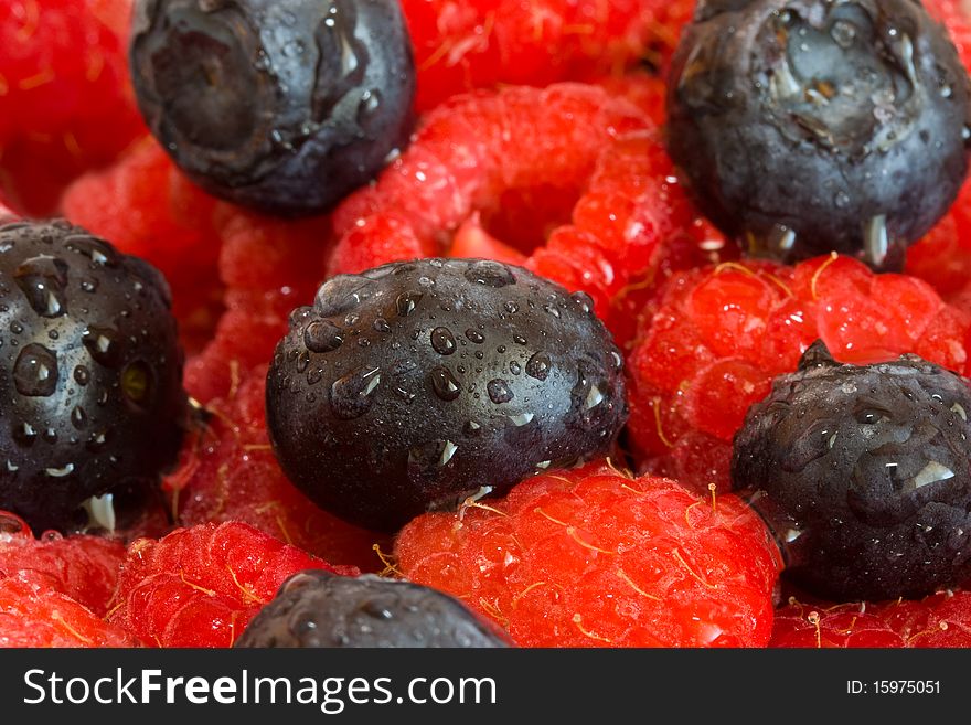 Wet blueberries and raspberries closeup