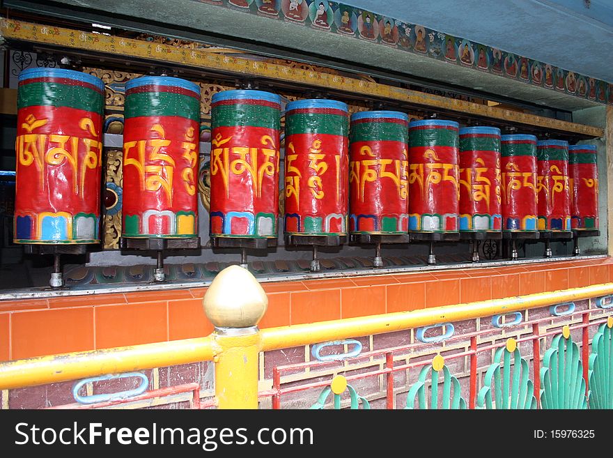 Buddhist prayer wheels in bright red with mantra written all over