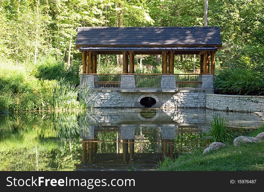 Peaceful setting with park pavilion and reflection in pond. Peaceful setting with park pavilion and reflection in pond.