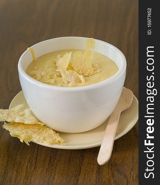 Bowl of cheese soup on plate with cheese chips