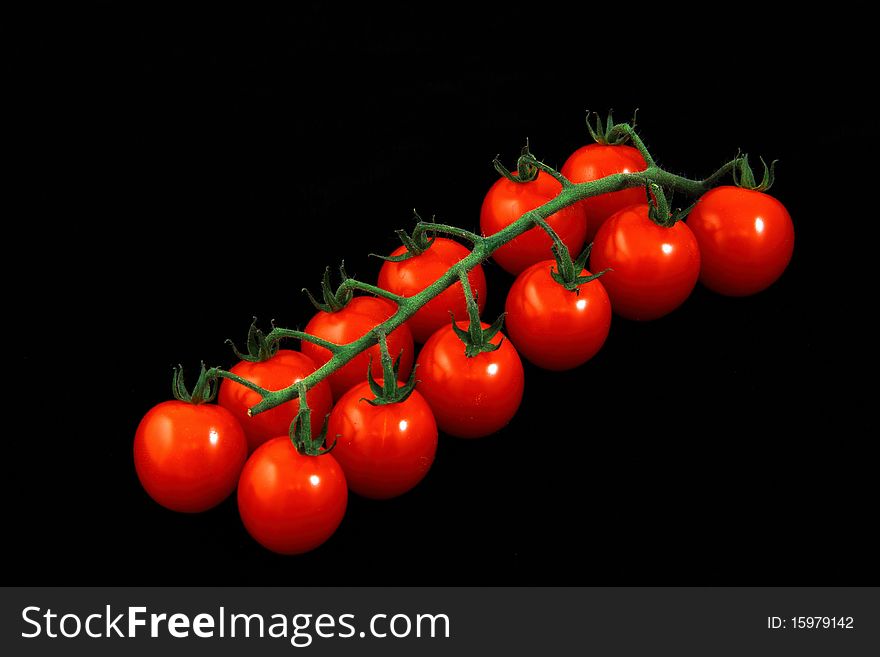 Bunch of red tomatoes on a black background