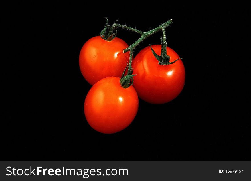 Bunch of red tomatoes on a black background is